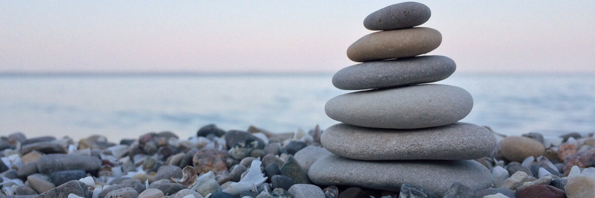 L'equilibrio è un componente essenziale di un'esistenza appagante Cumulo di sassi piatti in equilibrio, sulla sponda del mare