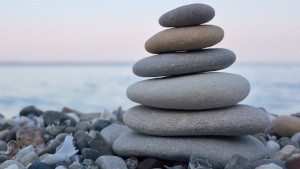 Cumulo di sassi piatti in equilibrio, sulla sponda del mare