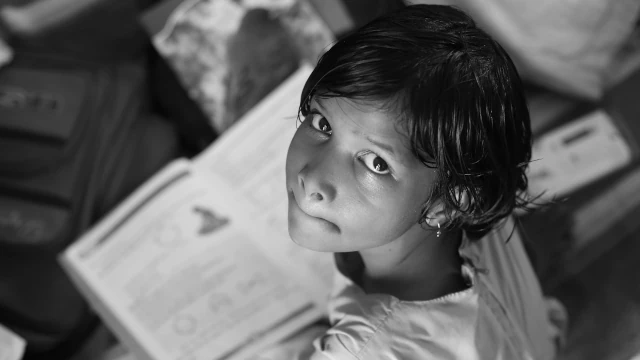Anche comportamenti apparentemente sani possono essere il segno di un problema, se si basano sull'ansia da prestazione Bambina con un libro scolastico in mano. Anche comportamenti apparentemente sani possono essere il segno di un problema, se si basano sull'ansia da prestazione