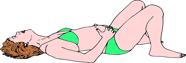 Donna sdraiata sulla schiena, con le gambe piegate e le mani sui lati dell'addome. È la respirazione di base